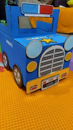 a cardboard truck bed sitting on top of a yellow floor