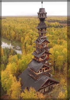 an aerial view of a tall tower in the middle of a forest with trees surrounding it