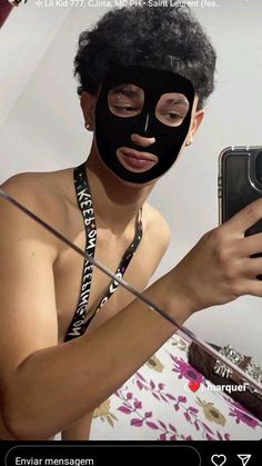 a woman wearing a black mask and holding a cell phone