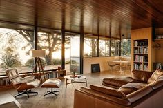 a living room filled with lots of furniture and bookshelves next to a window