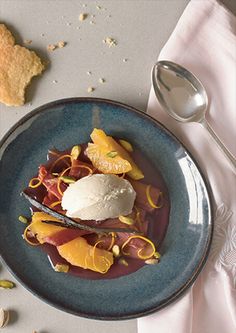 a blue plate topped with fruit and ice cream next to crackers on a table