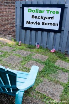 a blue wooden bench sitting in front of a sign that reads dollar tree backyard movie screen