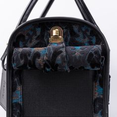 the back side of a black and blue handbag