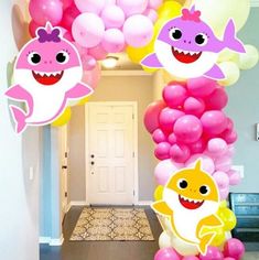 a bunch of balloons that are in the shape of shark and fish with faces on them