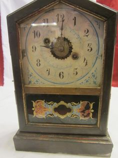 an antique clock with ornate designs on the face and sides, sitting on a white surface