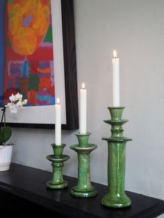 three candles sitting on top of a black table