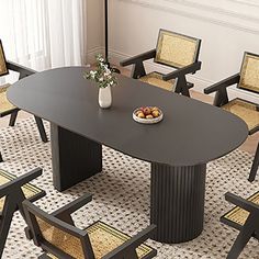 a dining room table with chairs and a bowl of fruit on the table next to it