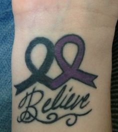 a wrist tattoo with the words believe and an awareness ribbon