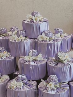 a large pile of purple wrapped presents with white flowers