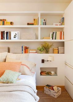 a bedroom with bookshelves and pillows on the bed