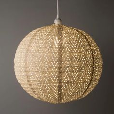 a light that is made out of woven material and hanging from a ceiling fixture in a room