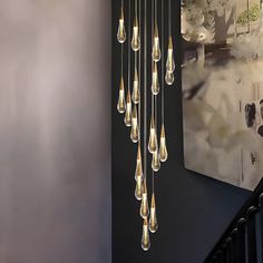 a chandelier hanging from the side of a wall next to a stair case