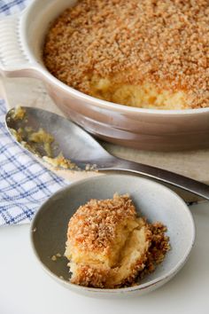 a dessert dish with crumbs on top and a serving spoon next to it