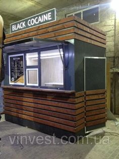 a man standing in front of a booth that is made out of wood and metal