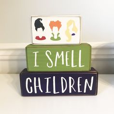 two wooden blocks with the words i smell children painted on them sitting on top of each other