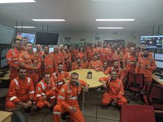 a group of men in orange uniforms posing for a photo