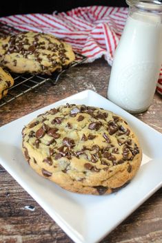 two cookies on a plate next to a glass of milk