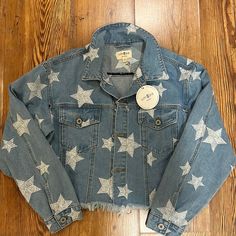 Umgee Denim Star Jacket Size Small. Nwt. White Stitched Stars.. Perfect Condition. Distressed Bottom . Button Pockets On Chest. Perfect For Holidays Denim Jacket With Star Print And Long Sleeves, Denim Jacket With Star Print, Long Sleeve Denim Jacket With Star Print, Blue Star Print Outerwear For Fall, Casual Spring Outerwear With Star Print, Casual Outerwear With Star Print For Spring, Fall Denim Jacket With Star Patch, Fall Denim Jacket With Star Print, Winter Denim Outerwear With Star Print