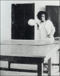 an old black and white photo of a woman throwing a frisbee