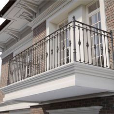 a balcony with wrought iron balconies and railings on the side of a brick building