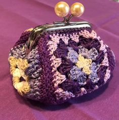 a crocheted purse with two pearls on top