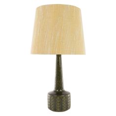 a green table lamp with a beige shade