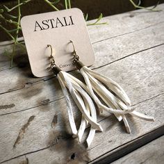 "-These tassel earrings are made from soft white deerskin leather. Part Western, part Boho, part Rock 'n Roll, these little fringe earrings give a big kick to any outfit. -Lightweight enough to wear every day. -3\" - 3.5\" total length, including earwires. -Earwires are antique-brass. -Deerskin leather is sustainably sourced in the USA. -Ok to get wet. -Available in 10 colors. -Designed and handmade in South Pasadena, CA. Check out more of our awesome earrings here: https://www.etsy.com/shop/AST Handmade White Leather Earrings, White Leather Earrings As A Gift, White Leather Earrings Gift, White Leather Earrings For Gift, Dangly Earring, Creepy Earrings, Awesome Earrings, White Tassel Earrings, Fringe Earring