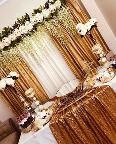 a table topped with lots of cakes and desserts covered in gold sequins