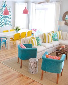 a living room filled with lots of furniture and colorful pillows on top of a rug