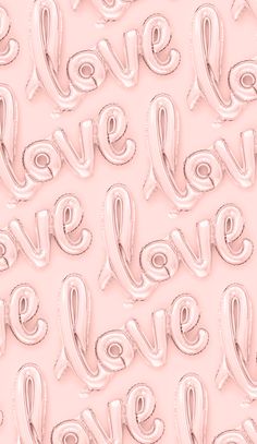 the word love spelled with balloons in pink and white on a light pink background for valentine's day