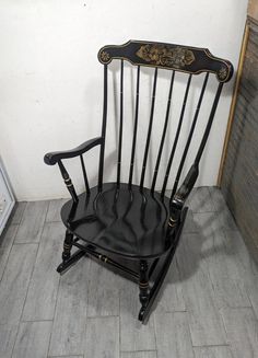 a black rocking chair sitting on top of a tile floor