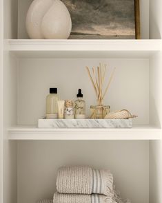 white shelves with towels, soaps and candles