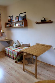 a room with a bed, desk and shelves