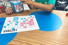 a young boy is playing with a board game on the table in front of him