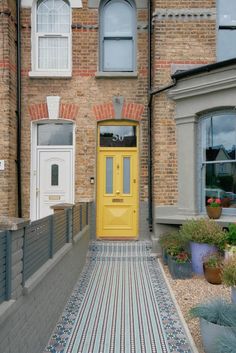 a yellow door in front of a brick building