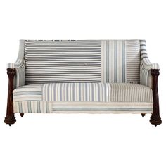 a striped couch with wooden legs and arms