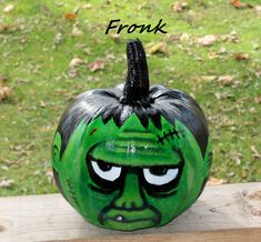 a green painted pumpkin with the words fronk on it's face and eyes