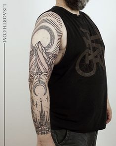 a man with a bicycle tattoo on his arm and shoulder, standing in front of a white wall