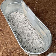 a metal tub filled with gravel sitting on the ground