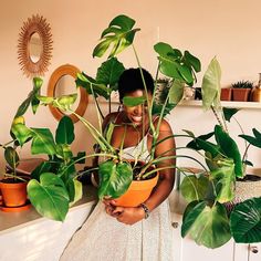 a woman holding a potted plant in her hands