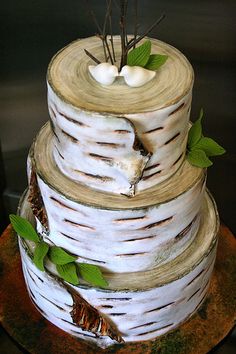 a three tiered cake with white frosting and green leaves