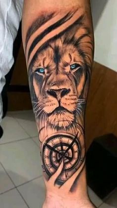 a man's leg with a lion and compass tattoo on it