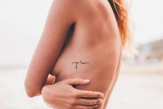 a woman with a small tattoo on her left side shoulder and the word love written in cursive font