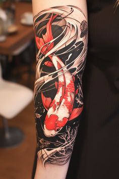 a woman's arm with a koi fish tattoo on it