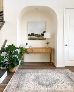 a living room with a rug and plant in it