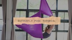 a woman in a purple hammock with the words butterfly pose tutor above her head