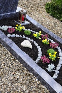 a small garden with rocks and flowers in the ground next to a fire hydrant