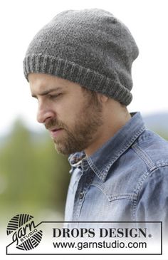 a man wearing a beanie looking down at his cell phone