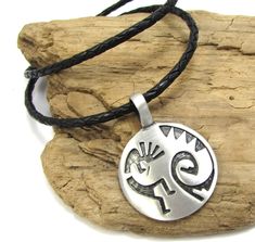 ~ Kokopelli Pendant Necklace. ~ One (1) Domed Round with Kokopelli Pendant (Selected at Random). ~ Color: Antiqued Pewter, ~ Size: 39x28mm Single Sided Kokopelli Pendant, ~ 3mm Braided Leather Cord Necklace, ~ Clasp: Stainless Steel Lobster Claw. ~ Available Colors: 1. Black 2. Antique Brown 3. Dark Brown 4. Saddle Tan 5. Natural 6. Antique Red 7. Black & Red 8. Black & Brown 9. Black & Silver ~ See Photo (9) for colors examples. ~ See Photo (10) to See Size and Back of Pendant. ~ Cr Adjustable Symbolic Stamped Necklace, Southwestern Silver Jewelry With Adjustable Cord, Braided Leather Necklace, Bolo Necklace, Necklace Clasp, Braided Necklace, Leather Corded Necklace, Necklace Clasps, Steampunk Jewelry