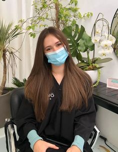 a woman sitting in a chair wearing a face mask